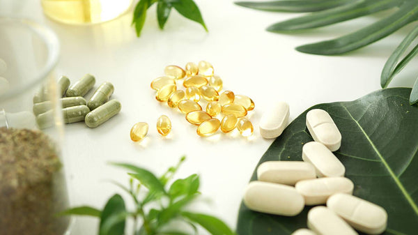 Pills and vitamins to boost your immune system on white counter with plants